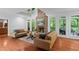 Cozy living room with stone fireplace, hardwood floors, and abundant natural light at 2910 Leeds Garden Ln, Alpharetta, GA 30022