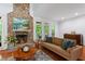 Inviting living room with stone fireplace, hardwood floors, and large windows at 2910 Leeds Garden Ln, Alpharetta, GA 30022