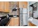 Functional kitchen with stainless steel appliances, brick backsplash, and wood cabinets at 30 5Th Ne St # 1006, Atlanta, GA 30308