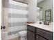 Bathroom featuring a vanity with sink, toilet, and shower with grey and white striped curtain at 4840 Chase Ln, Cumming, GA 30040