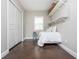 Small bedroom with unique shelving, closet, and bed, featuring a hardwood floor and neutral paint at 4840 Chase Ln, Cumming, GA 30040
