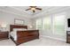 Bright bedroom featuring a tray ceiling, three windows and an elegant sleigh bed frame and carpet flooring at 4840 Chase Ln, Cumming, GA 30040