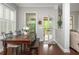 Bright dining area with wooden table and bench seating, flooded with natural light from large windows at 4840 Chase Ln, Cumming, GA 30040
