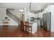 Open concept kitchen with island seating, stainless appliances, and access to the stairway at 4840 Chase Ln, Cumming, GA 30040