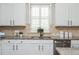 Bright kitchen featuring white cabinets, a stainless steel dishwasher, and beautiful granite countertops at 4840 Chase Ln, Cumming, GA 30040