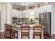 A kitchen with white cabinets, stainless steel appliances, an island, and modern lighting at 4840 Chase Ln, Cumming, GA 30040