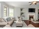 Neutral toned living room features fireplace with mounted TV and built-in shelving with wood flooring at 4840 Chase Ln, Cumming, GA 30040