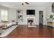 Spacious living room features beautiful fireplace and a built in neutral-toned bookshelf with hardwood floors at 4840 Chase Ln, Cumming, GA 30040
