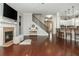 Open living room with fireplace, kitchen view, and stairway, perfect for entertaining and Gathering gatherings at 4840 Chase Ln, Cumming, GA 30040