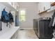 Gray mud room with washer and dryer along with hooks for coats and a built-in bench seat for storage at 4840 Chase Ln, Cumming, GA 30040