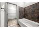 Close-up of a bathtub with stylish tile surround and a view into a walk-in closet at , Atlanta, GA 30313