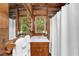 Bathroom featuring a wood paneled wall and vanity with view of trees outside at 15 Bailey St, Whitesburg, GA 30185