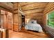 Cozy bedroom featuring wood walls, sloped ceiling, a window, and closet with wood floors at 15 Bailey St, Whitesburg, GA 30185