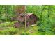 Exterior view of a two-story wood paneled cabin in the woods with greenery surrounding the property at 15 Bailey St, Whitesburg, GA 30185