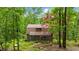 Secluded log home surrounded by lush greenery and mature trees, offering privacy at 15 Bailey St, Whitesburg, GA 30185