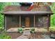 Inviting log cabin featuring a cozy front porch with stone accents and a welcoming pathway at 15 Bailey St, Whitesburg, GA 30185