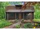 Charming log cabin with a covered porch, stone walkway, and well-manicured landscaping at 15 Bailey St, Whitesburg, GA 30185