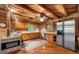 Rustic kitchen with wooden cabinets, stainless steel appliances, and a striking log cabin aesthetic at 15 Bailey St, Whitesburg, GA 30185