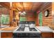 Cozy kitchen featuring a gas stovetop, wooden beams, and natural light from surrounding windows at 15 Bailey St, Whitesburg, GA 30185