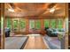 Bright sun room with wood floors, ceiling fans, and wooded backyard views at 15 Bailey St, Whitesburg, GA 30185