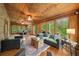 Large sun room with ceiling fans and multiple seating areas surrounded by nature at 15 Bailey St, Whitesburg, GA 30185
