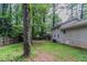 Backyard view of the home's exterior, featuring the siding, windows, AC unit, and mature trees at 1539 Pine Glen Cir, Decatur, GA 30035