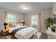 This staged bedroom features a queen bed and two windows for lots of natural light at 1539 Pine Glen Cir, Decatur, GA 30035