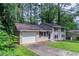 Split-level home with an attached garage and dark shutters at 1539 Pine Glen Cir, Decatur, GA 30035