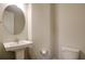 Neutral powder room featuring pedestal sink, oval mirror, and white toilet at 1949 Townsend Ne Ct # 22, Atlanta, GA 30329
