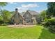 Large backyard featuring a stone patio, lush grass, and mature trees at 11880 Wexford Club Dr, Roswell, GA 30075