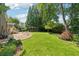 Expansive backyard with stone patio, mature landscaping, and lush lawn at 11880 Wexford Club Dr, Roswell, GA 30075