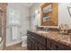 Charming bathroom with granite countertop, a custom mirror, and tile flooring at 11880 Wexford Club Dr, Roswell, GA 30075