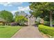 Inviting two-story home featuring a lush lawn, mature trees, and a long driveway at 11880 Wexford Club Dr, Roswell, GA 30075