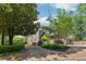 Home's exterior with a circular driveway, mature trees, and manicured landscaping at 11880 Wexford Club Dr, Roswell, GA 30075