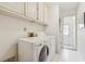 Bright laundry room featuring a washer, dryer, and storage cabinets at 11880 Wexford Club Dr, Roswell, GA 30075