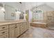 Spa-like main bathroom with dual sinks, soaking tub, glass enclosed shower, and natural light at 11880 Wexford Club Dr, Roswell, GA 30075