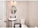 Compact bathroom featuring a pedestal sink, toilet, and convenient storage basket at 2314 Robin Dr, Loganville, GA 30052