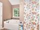 Bright bathroom featuring a soaking tub with decorative tile surround and unique shower curtain at 2314 Robin Dr, Loganville, GA 30052