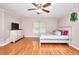 Bedroom with light neutral paint, ceiling fan, wood laminate floors and modern furniture at 2314 Robin Dr, Loganville, GA 30052