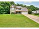 Well-maintained home on a lush green lawn with mature trees and an attached two-car garage at 2314 Robin Dr, Loganville, GA 30052