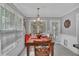 Dining area features a wood table, with decorative chandelier, and access to the screened porch at 100 Chestnut Hill Dr, Canton, GA 30114