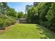 Green backyard with trees, a garden shed and a partial fence at 111 Terrace Ne Dr, Atlanta, GA 30305