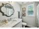 Bathroom featuring a granite sink, a gray decorative mirror, wood floors, and natural light from a window at 111 Terrace Ne Dr, Atlanta, GA 30305