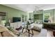 Comfortable room featuring a bed, desk, ceiling fan, light green walls, sofa, television, and French doors at 111 Terrace Ne Dr, Atlanta, GA 30305
