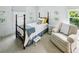 Cozy bedroom features a twin-size, four poster bed, a comfortable armchair, and bright, natural light at 111 Terrace Ne Dr, Atlanta, GA 30305