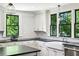 Eat-in kitchen with white cabinetry, stone counters, stainless appliances, and a farmhouse sink at 111 Terrace Ne Dr, Atlanta, GA 30305