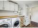 Laundry area with butcher block counters, utility sink, storage cabinets and laundry machines at 111 Terrace Ne Dr, Atlanta, GA 30305