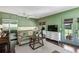 Living area with a sofa, piano, stainless steel refrigerator, television, French doors, and light green paint at 111 Terrace Ne Dr, Atlanta, GA 30305