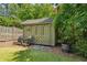 Backyard shed on a green lawn with two wooden chairs and double doors at 111 Terrace Ne Dr, Atlanta, GA 30305