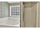 Bathroom showing soaking tub and separate shower with neutral tile at 1510 Summer Lake Ter, Loganville, GA 30052